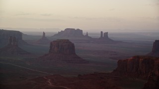 AX133_181 - 5.5K aerial stock footage of a wide view of Merrick Butte and nearby buttes in Monument Valley, Utah, Arizona, sunset