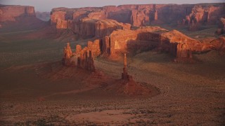 AX133_197E - 5.5K aerial stock footage of Yei Bi Chei Butte and Totem Pole Butte, Monument Valley, Utah, Arizona, sunset
