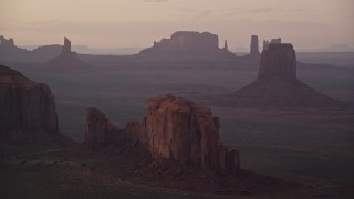 AX133_213E - 5.5K aerial stock footage of flying by East Mitten Butte, Elephant Butte in Monument Valley, Utah, Arizona, twilight