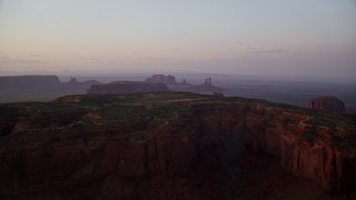 AX133_222 - 5.5K aerial stock footage of Mitchell Mesa and distant buttes, Monument Valley, Utah, Arizona, twilight