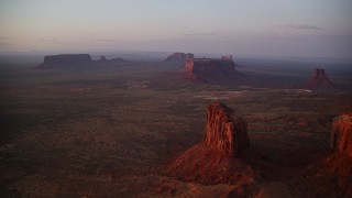 AX133_226E - 5.5K aerial stock footage view of Sentinel Mesa, buttes in Monument Valley, Utah, Arizona, twilight