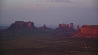 AX133_230E - 5.5K aerial stock footage of buttes in thick haze, Monument Valley, Utah, Arizona, twilight