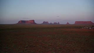 AX133_234 - 5.5K aerial stock footage of passing buttes between mesas, seen from airport in Monument Valley, Utah, Arizona, twilight