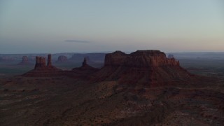 AX134_017E - 5.5K aerial stock footage of a view of buttes through hazy Monument Valley, Utah, Arizona, twilight