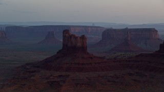AX134_019E - 5.5K aerial stock footage of passing by buttes and mesas, Monument Valley, Utah, Arizona, twilight