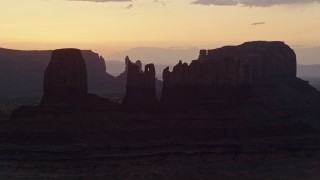 AX134_025 - 5.5K aerial stock footage of flying by several buttes in Monument Valley, Utah, Arizona, twilight