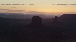 AX134_033 - 5.5K aerial stock footage of passing by Merrick Butte, West Mitten Butte in Monument Valley, Utah, Arizona, sunset