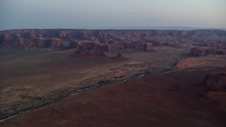 AX134_034E - 5.5K aerial stock footage of flying toward buttes, rock formations in Monument Valley, Utah, Arizona, twilight