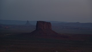 AX134_066E - 5.5K aerial stock footage of passing by Mitchell Butte in Monument Valley, Utah, Arizona, twilight