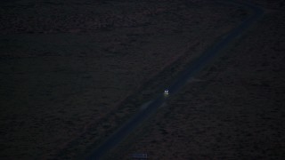 AX134_068 - 5.5K stock footage aerial video of tracking SUV on highway in desert valley, Monument Valley, Utah, Arizona, twilight