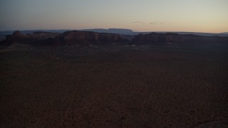 AX134_071 - 5.5K aerial stock footage video of flying by small town and Oljeto Mesa in Goulding, Utah, twilight