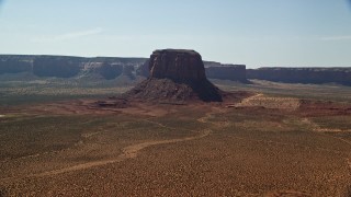 AX135_005E - 5.5K aerial stock footage of passing by Mitchell Butte and desert, Monument Valley, Utah, Arizona