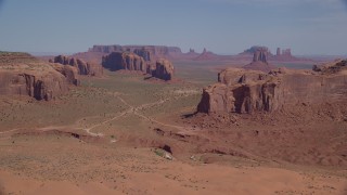 AX135_026 - 5.5K stock footage aerial video of flying by numerous buttes and mesas in a desert valley, Monument Valley, Utah, Arizona
