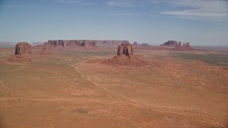 AX135_034E - 5.5K aerial stock footage of a wide view of several buttes and mesas in a desert valley, Monument Valley, Utah, Arizona