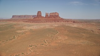 AX135_043E - 5.5K aerial stock footage of an approach to buttes in a desert valley, Monument Valley, Utah, Arizona