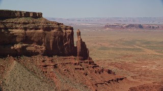 AX135_054E - 5.5K aerial stock footage of a reverse view of Eagle Rock Butte by Eagle Mesa, Monument Valley, Utah, Arizona