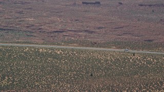 AX135_066E - 5.5K aerial stock footage of a car slowing to a stop on Highway 163, Monument Valley, Utah, Arizona