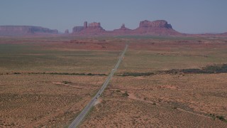 AX135_077 - 5.5K stock footage aerial video of flying by Highway 163 while approaching distant buttes, Monument Valley, Utah, Arizona