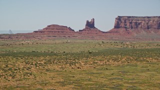 AX135_099 - 5.5K aerial stock footage of orbiting around grazing horses, giant buttes in the background, Monument Valley, Utah, Arizona