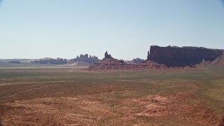 AX135_122E - 5.5K aerial stock footage of approaching Rooster Rock in a desert valley, Monument Valley, Utah, Arizona