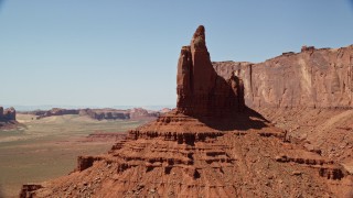 AX135_128E - 5.5K aerial stock footage of orbiting Rooster Rock and Meridian Butte, Monument Valley, Utah, Arizona