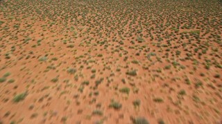 AX135_134E - 5.5K aerial stock footage tilt from from desert to reveal and fly toward Rooster Rock, Monument Valley, Utah, Arizona