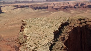 AX135_153E - 5.5K aerial stock footage of flying over Meridian Butte, pan across the top of the butte, Monument Valley, Utah, Arizona
