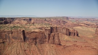 AX135_157E - 5.5K aerial stock footage of flying by top of Hunt's Mesa in Monument Valley, Utah, Arizona