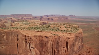 AX135_160E - 5.5K aerial stock footage of flying over Hunt's Mesa, approach wide desert valley, Monument Valley, Utah, Arizona