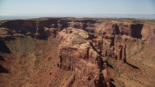 AX135_164E - 5.5K aerial stock footage of flying past Hunt's Mesa and sparse desert vegetation, Monument Valley, Utah, Arizona