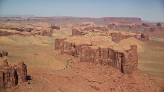 AX135_172E - 5.5K aerial stock footage of flying by a group of desert buttes and mesas, Monument Valley, Utah, Arizona