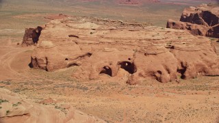 AX135_179 - 5.5K aerial stock footage of flying by caves, rock formations in Monument Valley, Utah, Arizona