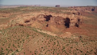 AX135_186E - 5.5K aerial stock footage of a view of Mitchell Mesa in hazy desert valley, Monument Valley, Utah, Arizona