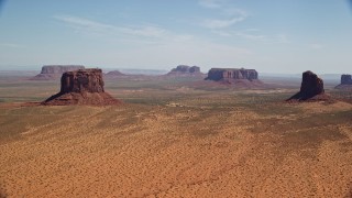 AX135_192E - 5.5K aerial stock footage of passing by open desert with buttes and mesas, Monument Valley, Arizona, Utah