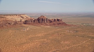 AX135_196E - 5.5K aerial stock footage of passing town of Goulding by Rock Door Mesa, Navajo Nation Reservation, Utah, Arizona
