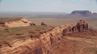 AX135_198E - 5.5K aerial stock footage of a wide view of Monument Valley buttes seen from Rock Door Mesa, Navajo Nation Reservation, Utah, Arizona