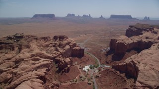 AX135_201 - 5.5K aerial stock footage of passing Goulding between Oljeto Mesa and Rock Door Mesa, Navajo Nation Reservation, Utah, Arizona