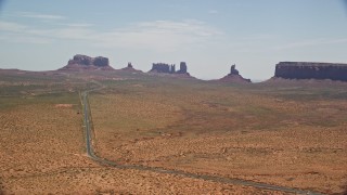 AX136_002E - 5.5K aerial stock footage of flying by Highway 163 leading to buttes in Monument Valley Arizona, Utah