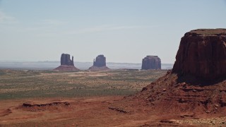 AX136_006E - 5.5K aerial stock footage of four desert buttes in a hazy valley, Monument Valley, Utah, Arizona