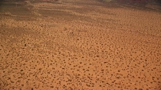 AX136_009E - 5.5K aerial stock footage tilt from desert, revealing Mitchell Mesa in Monument Valley, Utah, Arizona