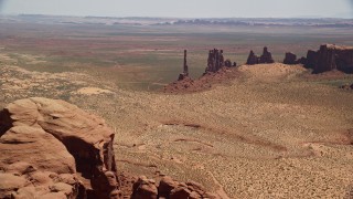 AX136_021E - 5.5K aerial stock footage of approaching Totem Pole Butte, Yei Bi Chei Butte, Monument Valley, Utah, Arizona