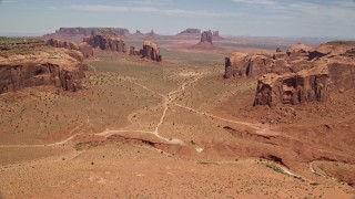 AX136_023E - 5.5K aerial stock footage of passing desert buttes and mesas to approach more landmarks in Monument Valley, Utah, Arizona