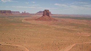 AX136_027 - 5.5K stock footage aerial video tilt from desert valley to reveal East Mitten Butte, Monument Valley, Utah, Arizona