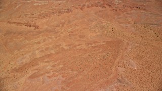 AX136_030E - 5.5K aerial stock footage tilt from desert valley to reveal East Mitten Butte, Monument Valley, Utah, Arizona