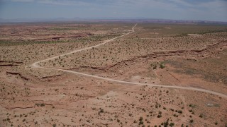 AX136_049 - 5.5K stock footage aerial video of approaching Douglas Mesa Road, Navajo Nation Reservation, Utah, Arizona