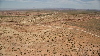 AX136_049E - 5.5K aerial stock footage of approaching rural homes beside Douglas Mesa Road, Navajo Nation Reservation, Utah, Arizona