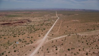 AX136_050 - 5.5K stock footage aerial video of approaching rural homes beside Douglas Mesa Road, Navajo Nation Reservation, Utah, Arizona
