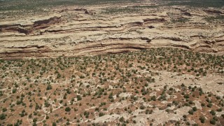 AX136_071E - 5.5K aerial stock footage of approaching canyon from mesa, pan to box canyon, Cedar Mesa, Utah