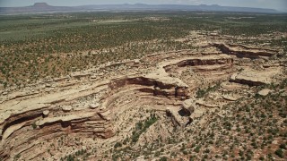 AX136_073E - 5.5K aerial stock footage orbit a desert canyon and a mesa, Cedar Mesa, Utah
