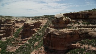 AX136_105 - 5.5K aerial stock footage of orbiting giant boulder atop canyon cliff, Grand Gulch Primitive Area, Utah